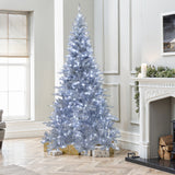 7.5 Ft Artificial Christmas Tree with white lights stands in living room by the fireplace, with wrapped gifts underneath.