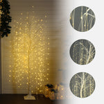 Artificial willow tree with cascading warm yellow string lights, close-up insets the lights,branches on the right. 