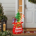 Festive outdoor display shaped like stocking with gifts,candy cane, tree stands by front door.