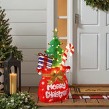 Festive outdoor display shaped like stocking with gifts,candy cane, tree stands by front door.