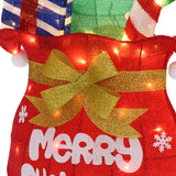 Close-up of red Holiday Decor, a gold bow, white snowflakes, the word “Merry” partially visible, all illuminated.