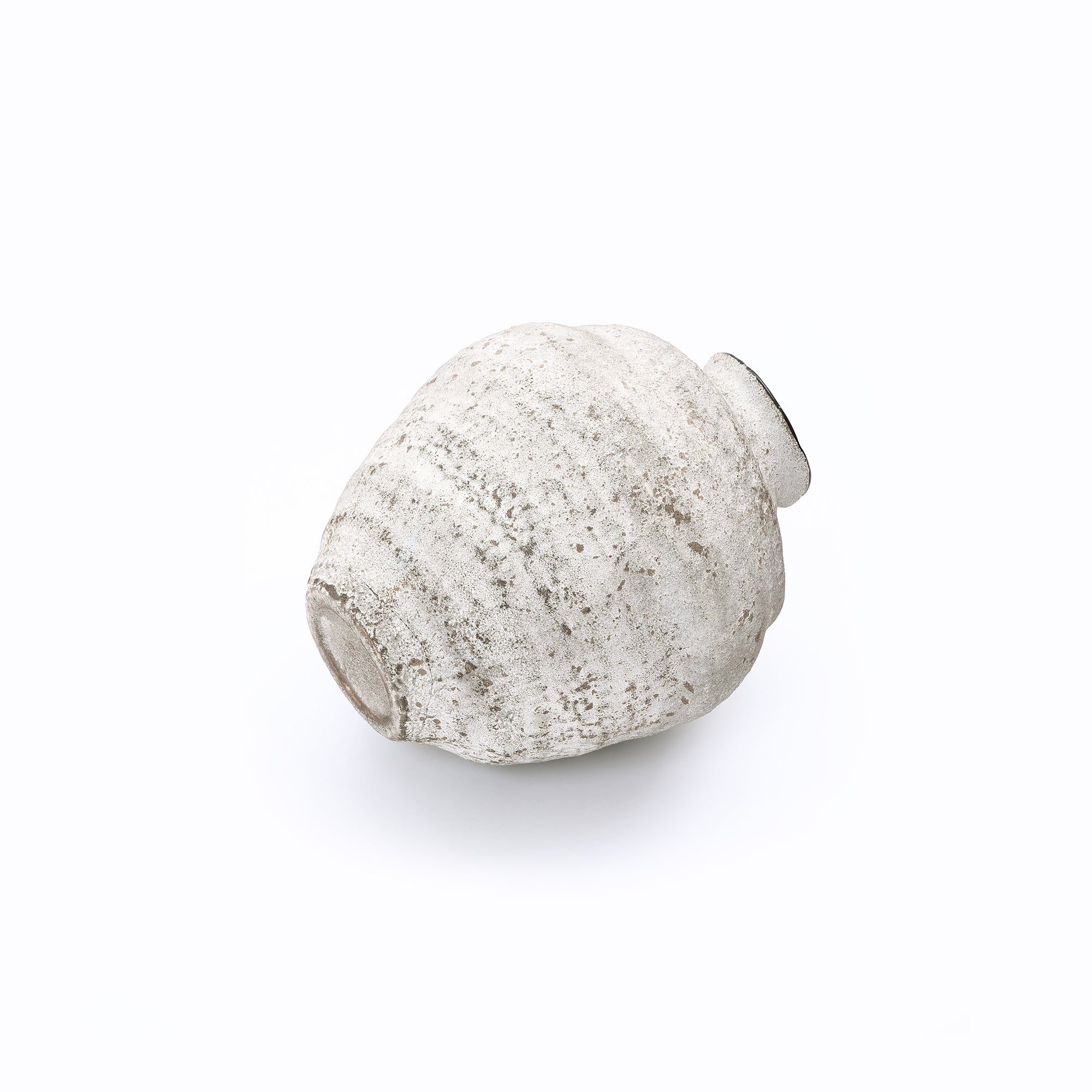 Small off-white cement vase lies on its side against a plain white background, making statement for home décor.