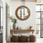Sits below a round wall mirror with an oak wood frame on a white wall in a bright, modern entryway.
