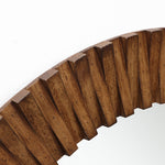 Close-up of a round wall mirror with a thick, ridged oak wood frame featuring a striking diagonal pattern.