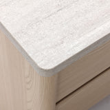 Close-up of a light wood cabinet with a textured, stone-like surface and two visible drawer fronts.