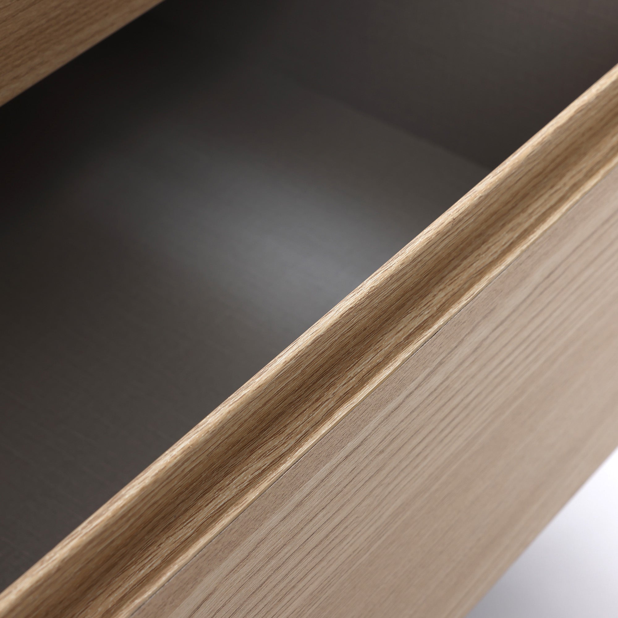 Close-up view of an open modern end table drawer, showing light wood grain texture and empty interior.