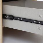 Close-up of a modern end table, showing a black metal sliding rail mechanism attached to the side of the drawer and cabinet.