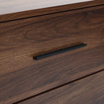 Close-up of a dark walnut dresser drawer with a black horizontal handle.