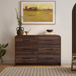 A walnut dresser with six drawers decor with vases, bowls, and books.