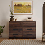 A walnut dresser with six drawers decor with vases, bowls, and books.