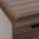 Close-up of the top corner of a walnut nightstand with a smooth finish and a dark metal handle.