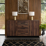 wood sideboard cabinet with drawers, cabinets is placed against  wooden wall, topped with2 lamps, books.