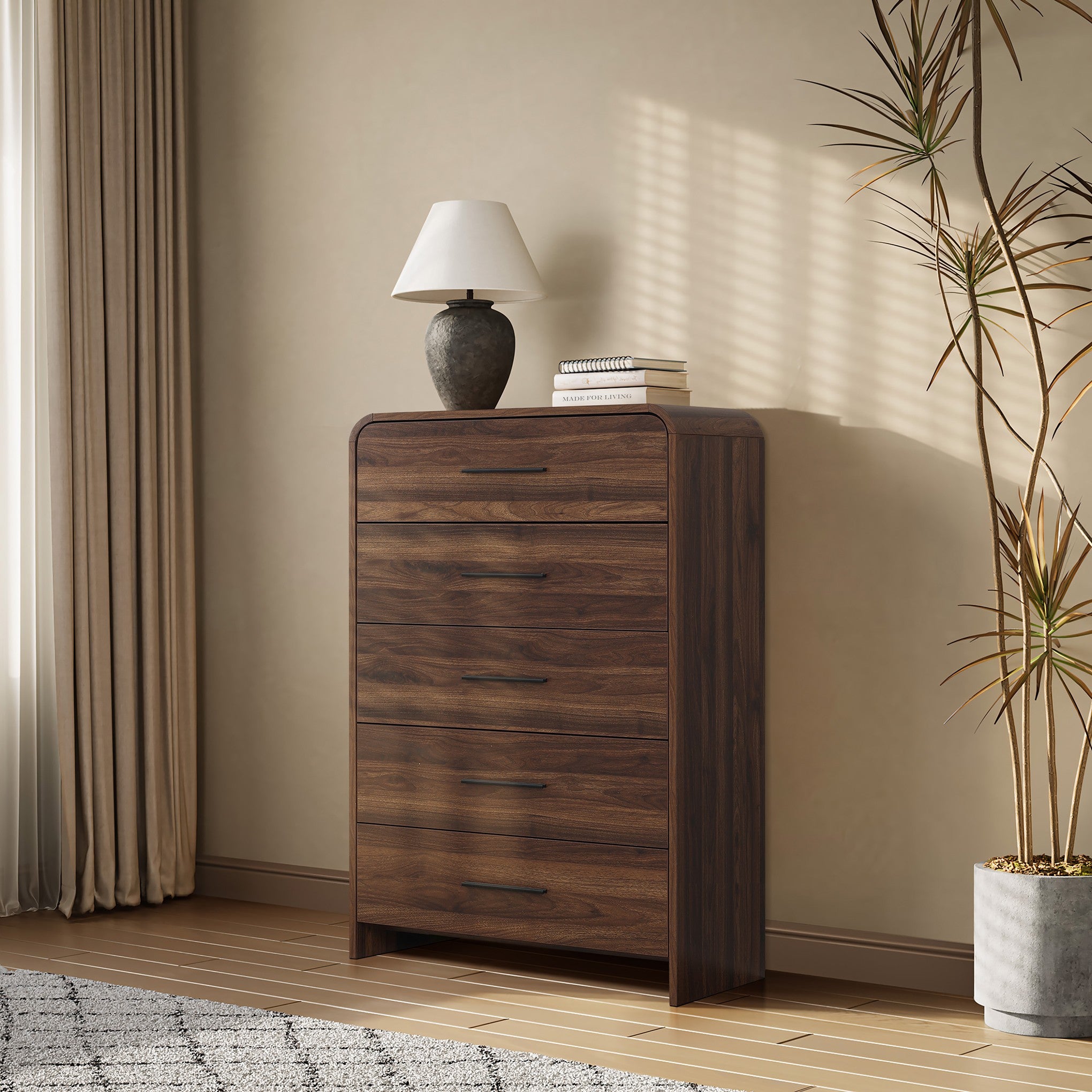 A dark wood storage vertical chest with five handles, topped with a ceramic lamp and stacked books.
