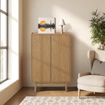 Light oak wood storage cabinet stands against the wall, topped with a small lamp and framed artwork.