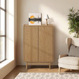 Light oak wood storage cabinet stands against the wall, topped with a small lamp and framed artwork.