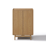 Rectangular light oak wood storage cabinet with two doors and a minimalist design, standing on four short legs.