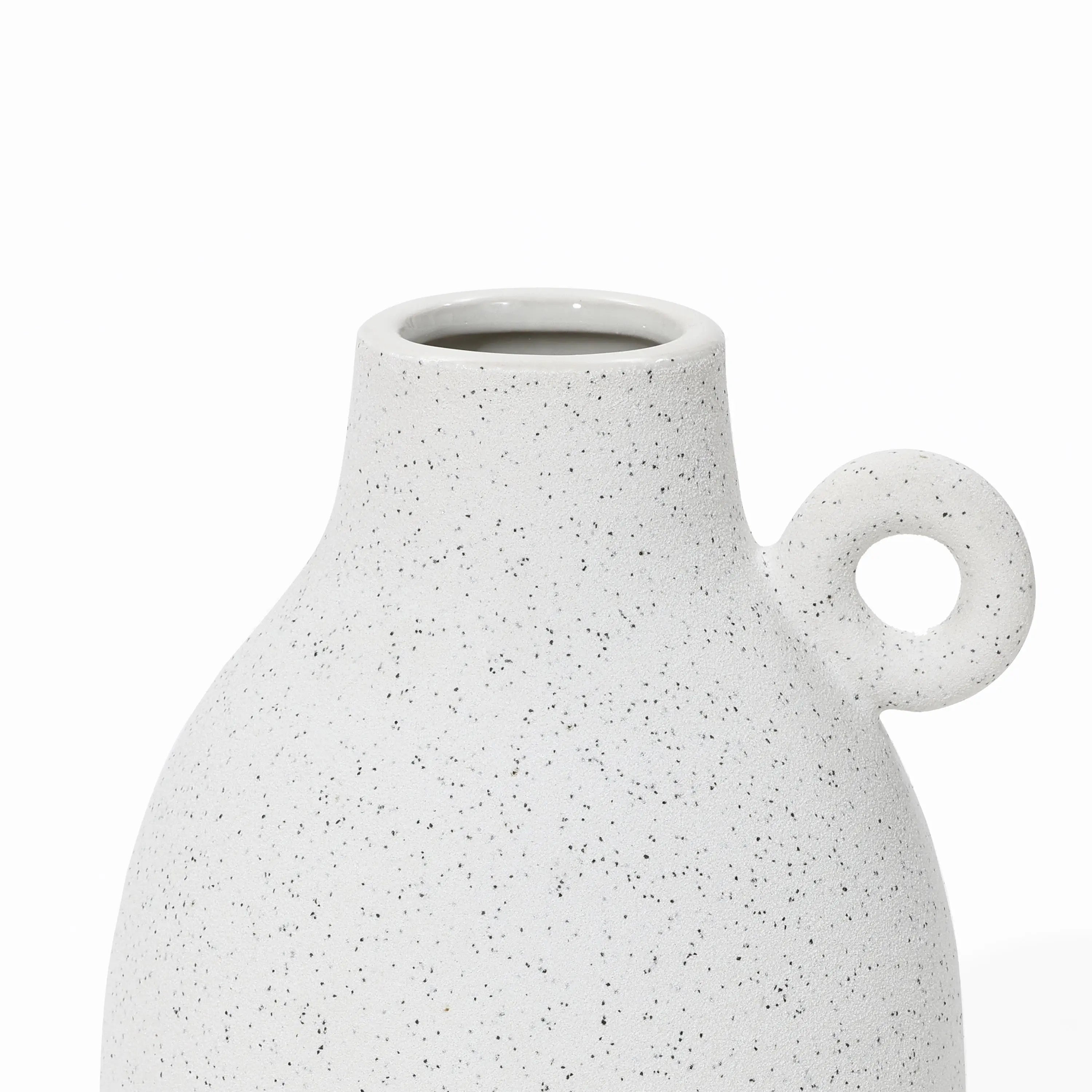 A speckled white ceramic vase with a round handle on one side, featuring a wide opening at the top and showcasing a vintage-inspired design.