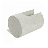 A speckled, ivory white cylindrical object with a slanted top and U-shaped design, resembling a minimalist sculpture, stands elegantly on a white background.