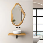 An asymmetrical wooden-framed mirror serves as a versatile accent above a minimalist sink and wooden shelf, perfectly complementing the organic feel of the space, with a stunning city view through the large window on the side.