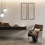 Modern living room with a gray armchair, blanket, cushion, floating shelf with stacked books, two pendant lights, and modern wall art as the focal point on a light gray wall.