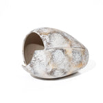 Ceramic vase with a textured, speckled surface reminiscent of marble in shades of white, grey, and brown. The design features an asymmetrical, elongated shape with a cutout opening, evoking a broken egg design.