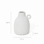 With its vintage-inspired design, this white speckled ceramic jug features a classic loop handle. Dimensions: 6.89 inches high, 5.31 inches deep, 5.71 inches wide—perfect as a charming accent piece or terracotta vase lookalike for any space.