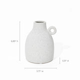 With its vintage-inspired design, this white speckled ceramic jug features a classic loop handle. Dimensions: 6.89 inches high, 5.31 inches deep, 5.71 inches wide—perfect as a charming accent piece or terracotta vase lookalike for any space.