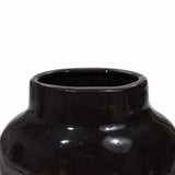 Close-up of a glossy black ceramic vase, perfect for home decor. Its smooth surface and wide opening are complemented by a subtle color block gradient, adding a touch of elegance to this vintage ceramic vase.