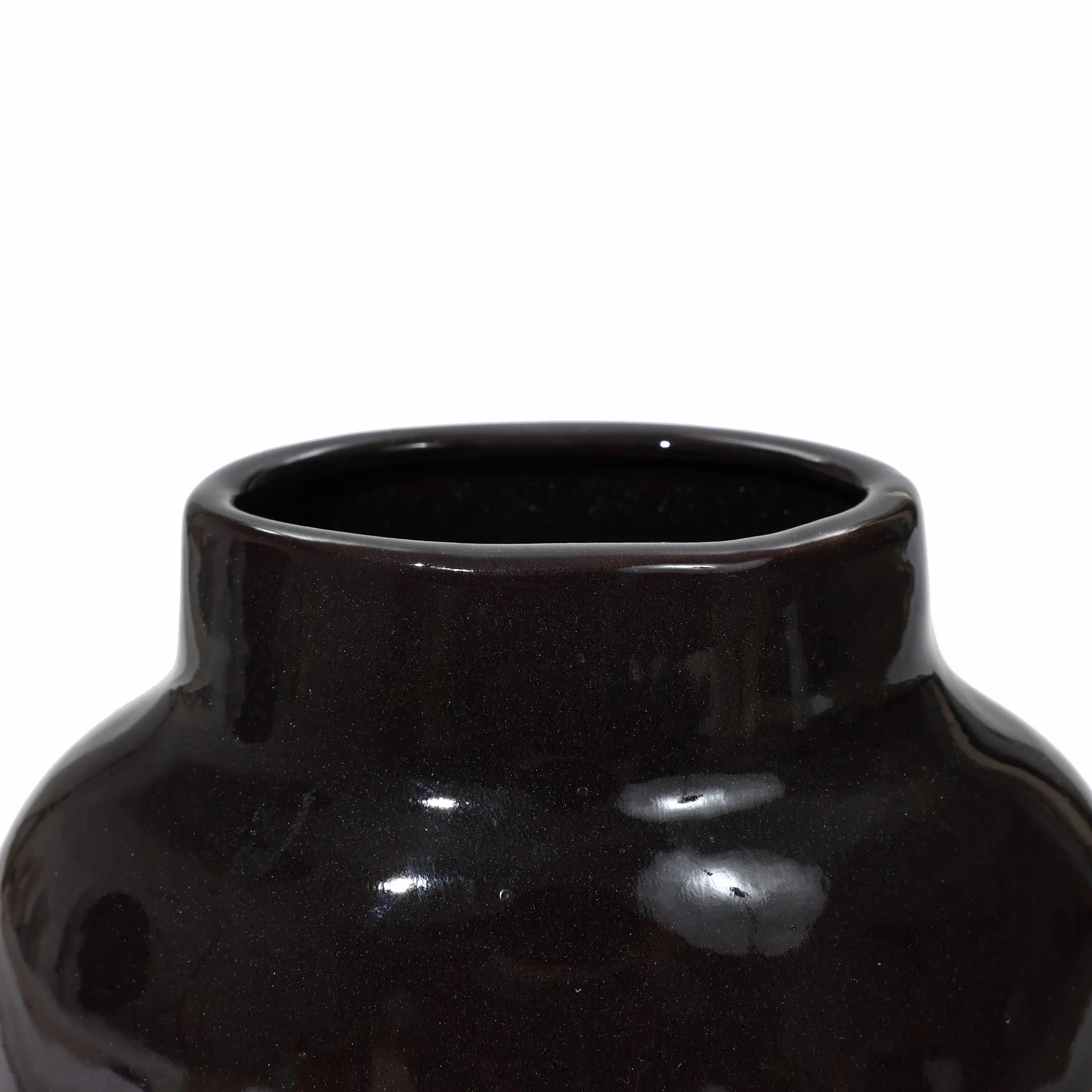 Close-up of a glossy black ceramic vase, perfect for home decor. Its smooth surface and wide opening are complemented by a subtle color block gradient, adding a touch of elegance to this vintage ceramic vase.