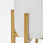 Close-up of a white fluted planter on a gold metal stand, featuring lightweight construction and a minimalistic design.