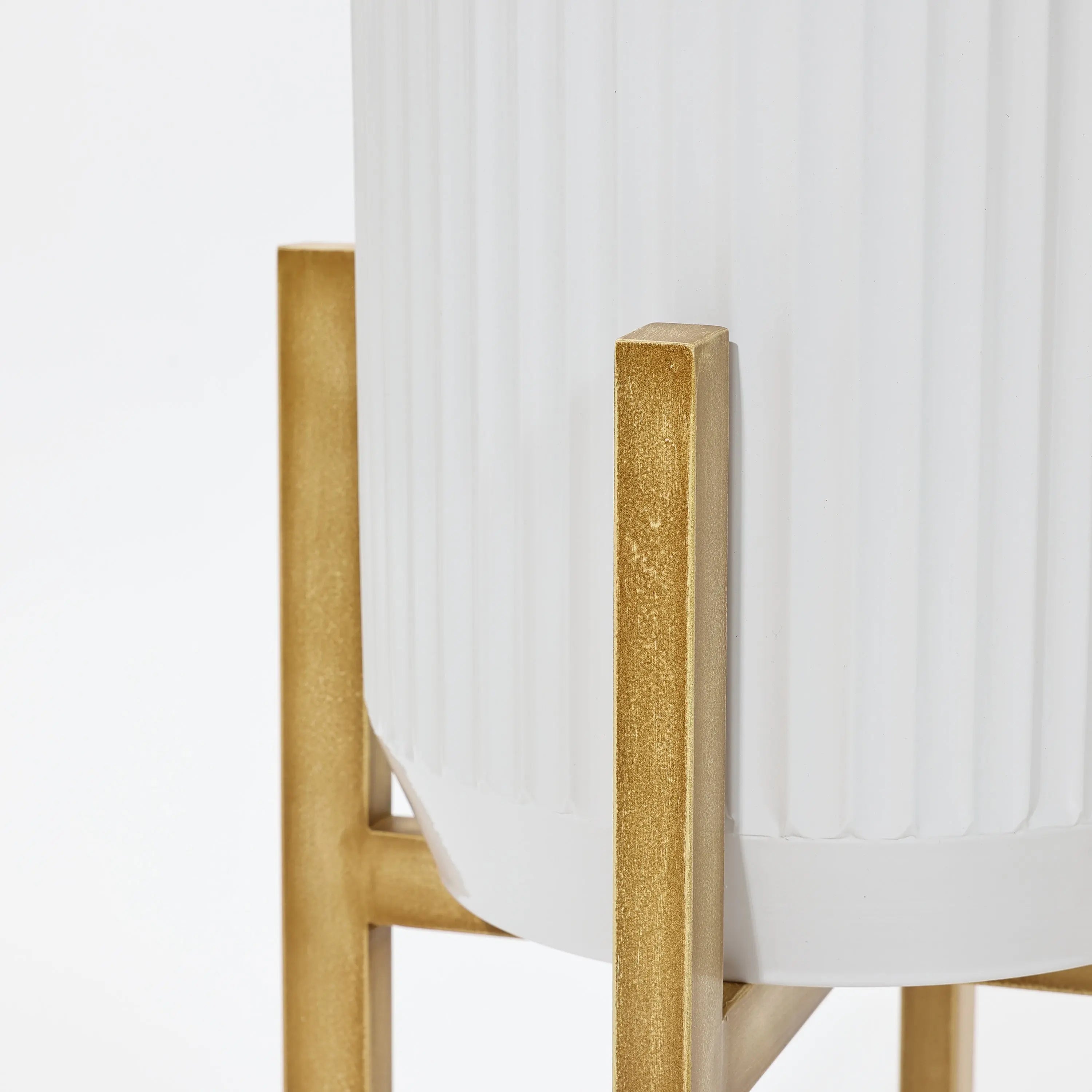 Close-up of a white fluted planter on a gold metal stand, featuring lightweight construction and a minimalistic design.