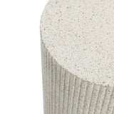 Close-up of a textured, cylindrical ivory white side table with a speckled surface and vertical ridges, crafted from durable cement material.