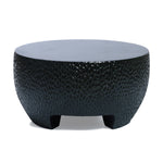 Round black textured coffee table with short legs, featuring a hammered design, ideal as a black cement outdoor coffee table.