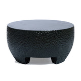 Round black textured coffee table with short legs, featuring a hammered design, ideal as a black cement outdoor coffee table.