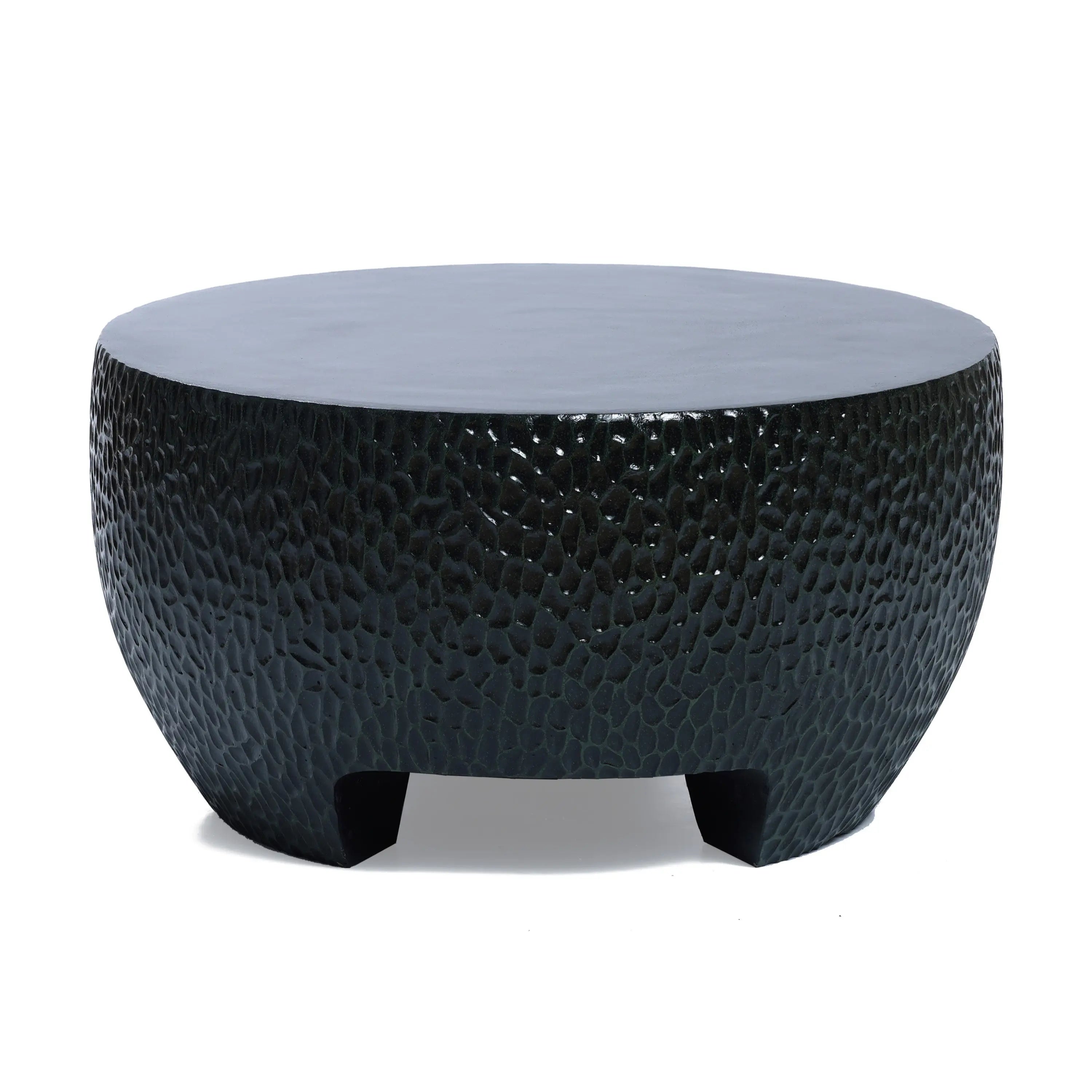 Round black textured coffee table with short legs, featuring a hammered design, ideal as a black cement outdoor coffee table.