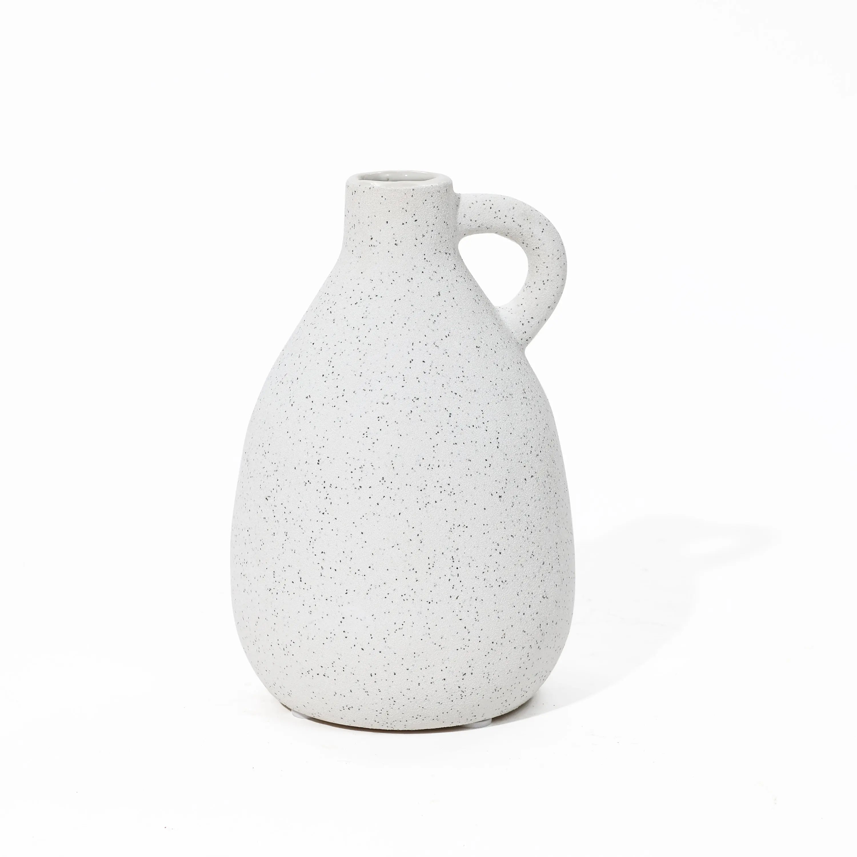 A speckled white ceramic vase with a handle on a white background, this vintage-inspired piece adds charm to any home decor setting.