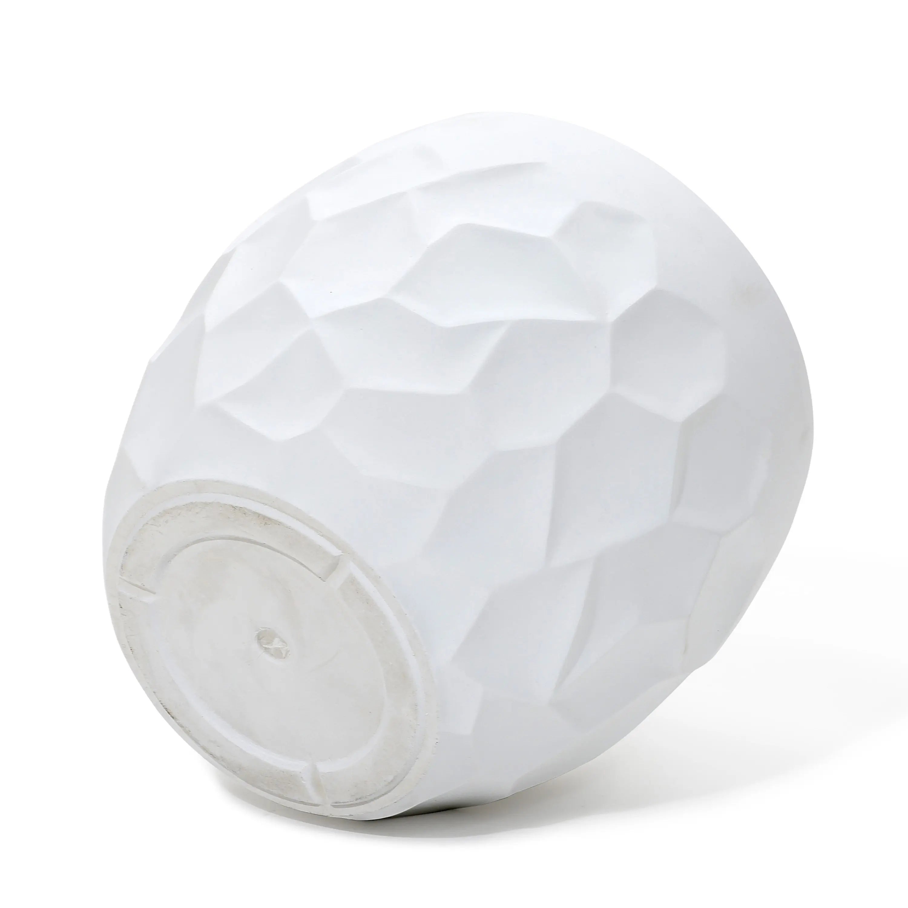 A textured white ceramic bowl, reminiscent of a geometric pot planter, turned upside down on a white surface.