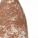 Close-up of a textured, brown and white speckled surface resembling handcrafted earthenware, exuding rustic charm.