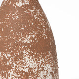 Close-up of a textured, brown and white speckled surface resembling handcrafted earthenware, exuding rustic charm.