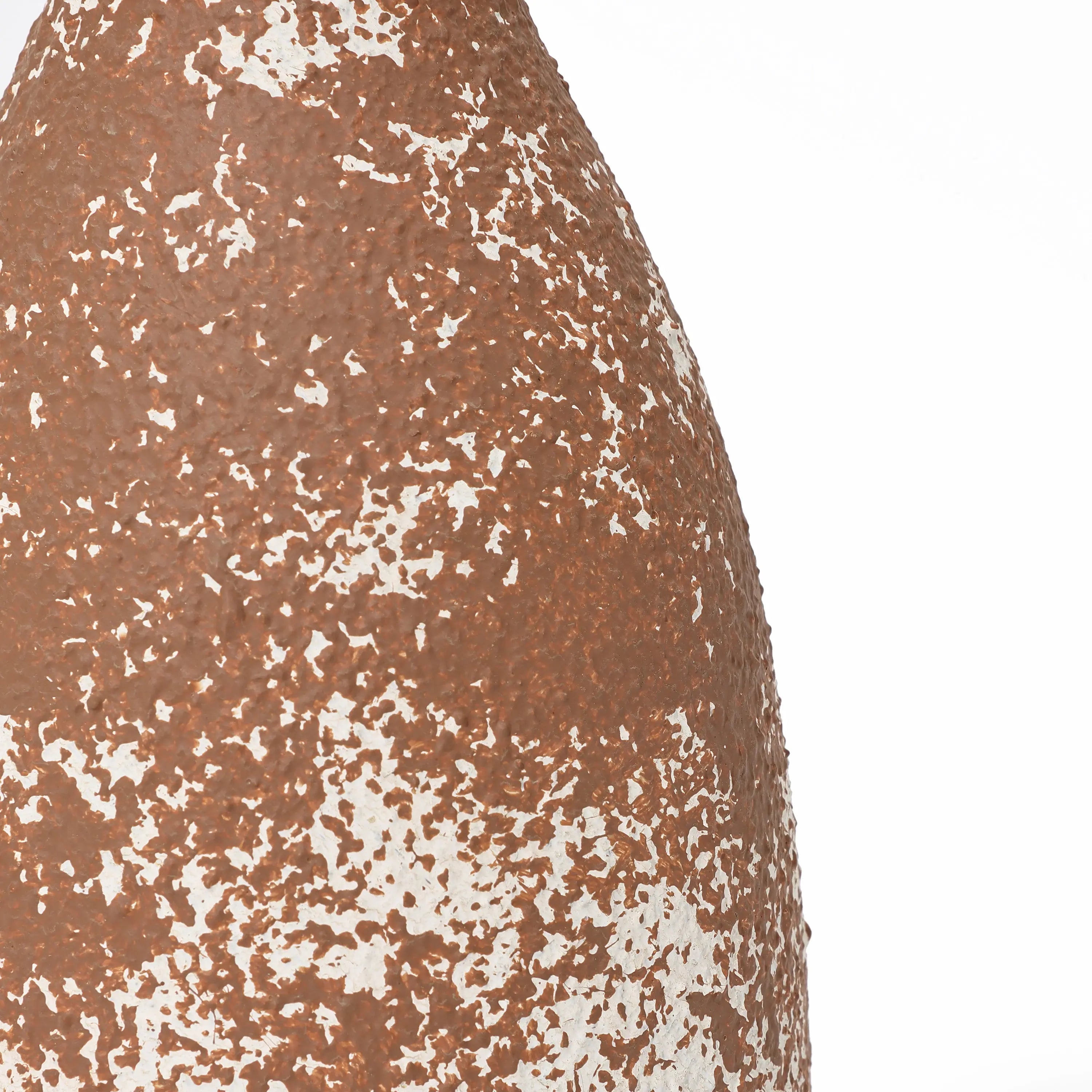 Close-up of a textured, brown and white speckled surface resembling handcrafted earthenware, exuding rustic charm.