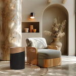 A modern living room with a wooden armchair, a decorative side table featuring a wooden top, woven rug, a large vase with dried grasses, and a wall sconce. This versatile piece complements the neutral tones and natural textures of the decor.
