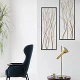 A modern living space featuring a dark blue armchair, a gold desk lamp on a round table, a potted plant, and striking modern wall art that serves as a focal point with its gold and silver branch designs.