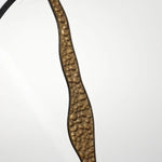 A thin, curved strip with a textured, brown surface bordered by black edges against a plain white background embodies an artistic design that complements modern decoration.