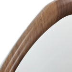 Close-up of a wooden chairs armrest, showcasing its smooth, curved design and visible wood grain that exudes Scandinavian charm.