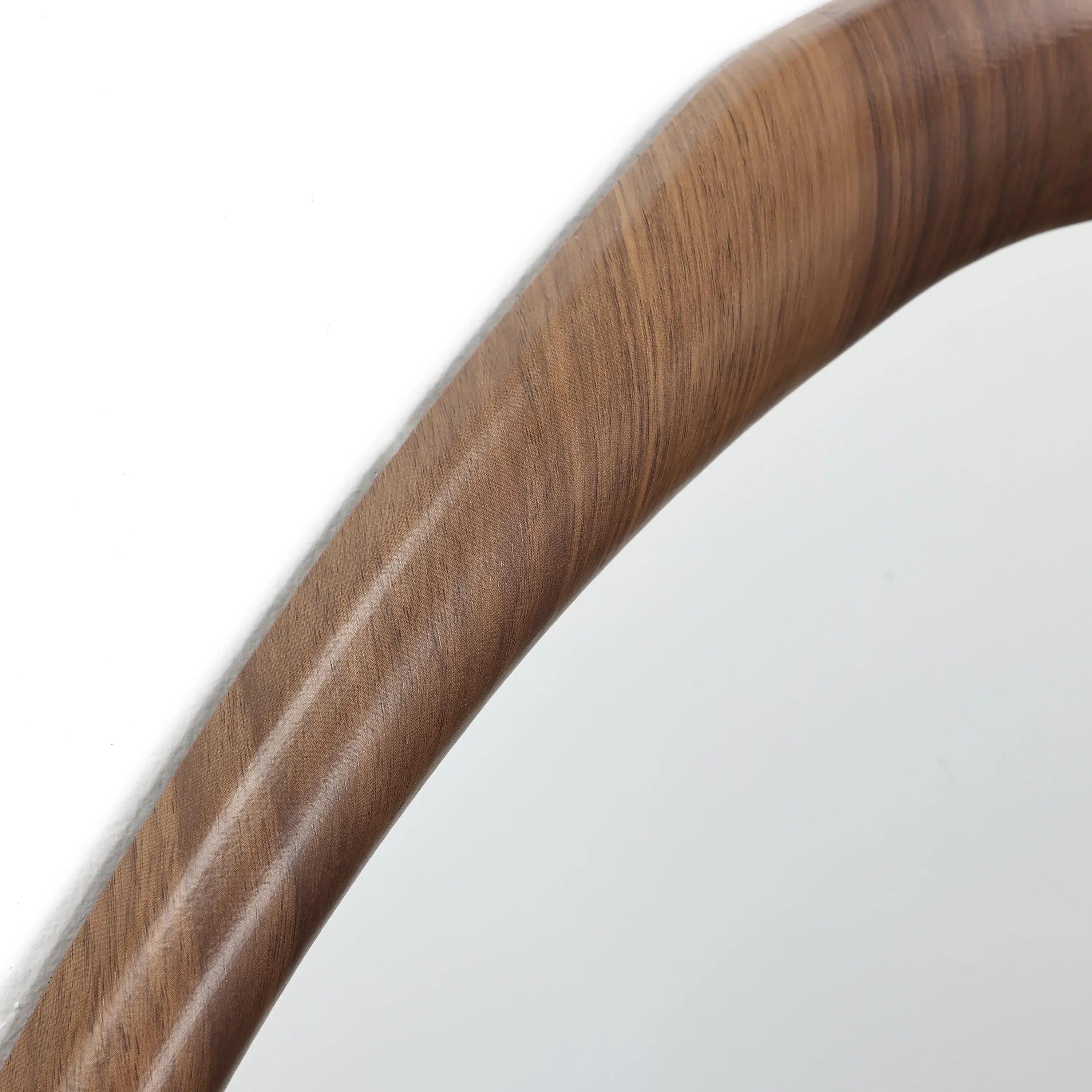 Close-up of a wooden chairs armrest, showcasing its smooth, curved design and visible wood grain that exudes Scandinavian charm.