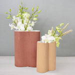 two-cylindrical-vases-with-white-flowers-in-them