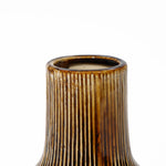 Close-up of a unique ceramic vase with vertical ridges against a white background.