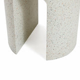 Close-up of a textured, speckled light gray surface with an ivory-white cement finish, featuring a geometric opening that suggests a modern sculpture or architectural detail—an ideal touch for an outdoor side table.