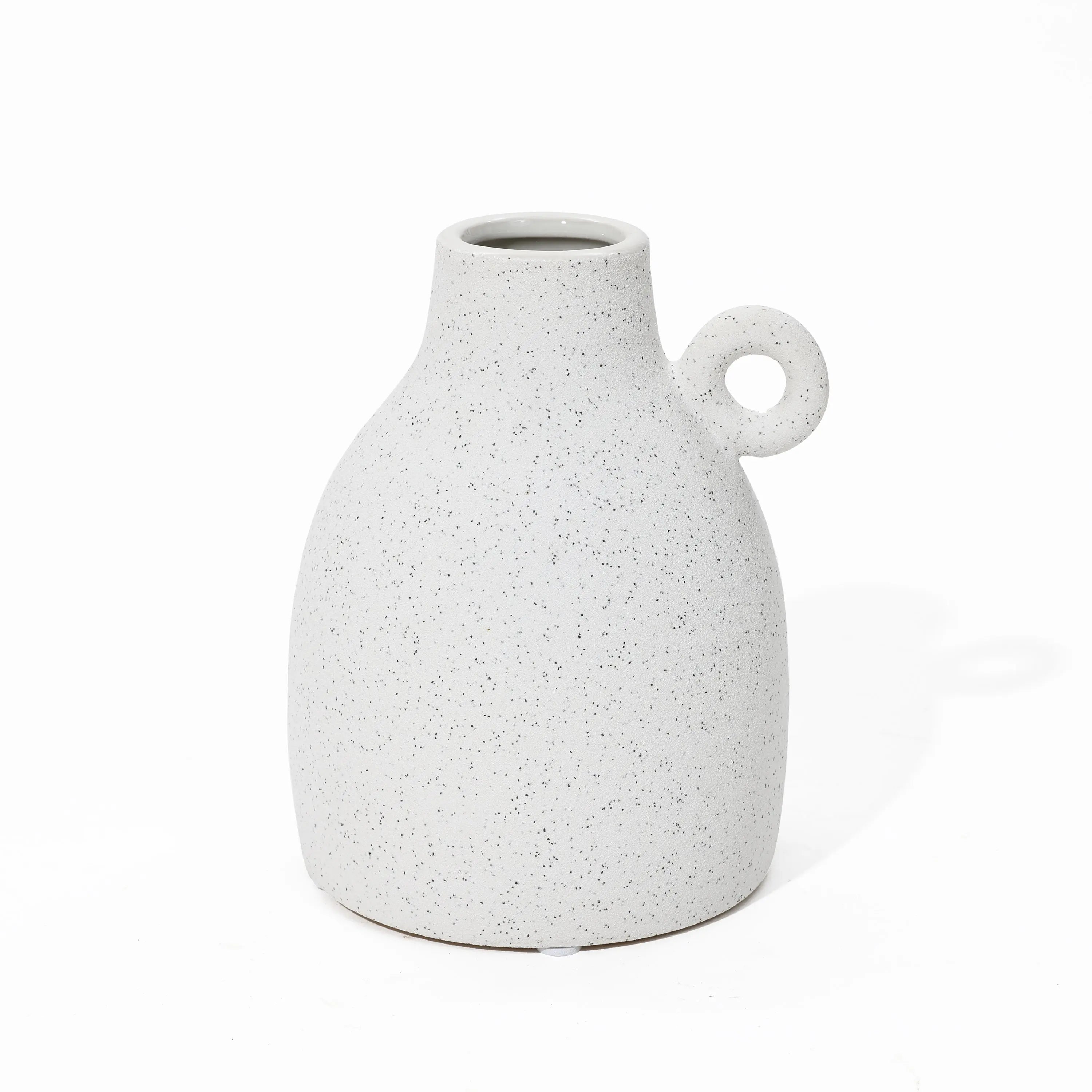 A vintage-inspired design emerges in this speckled white ceramic vase, featuring a rounded body and a loop handle on one side, set elegantly against a plain white background.