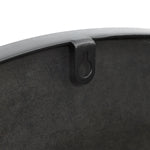 Close-up of a black metal pan with an artistic design, featuring a hanging loop on the side.